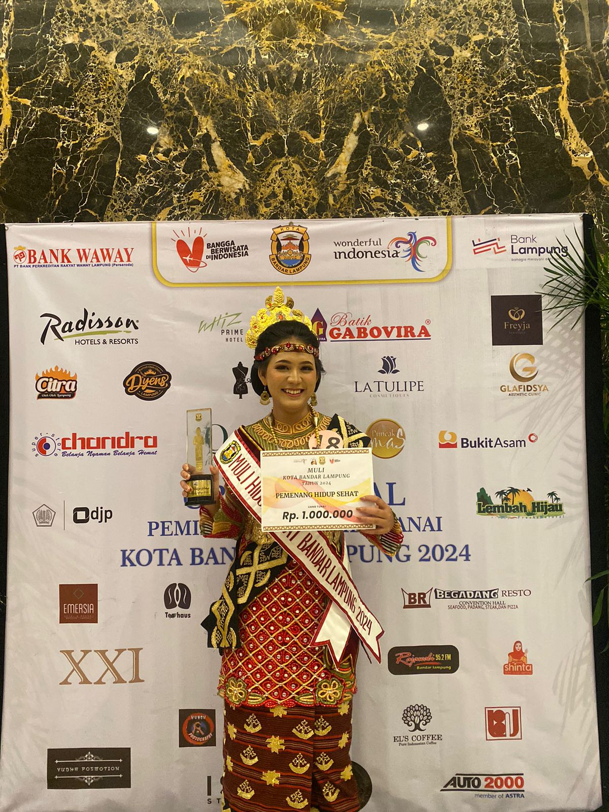 Mahasiswa Gentiaras berbusana adat Muli memegang piagam Pemenang Hidup Sehat ajang Muli Kota Bandar Lampung